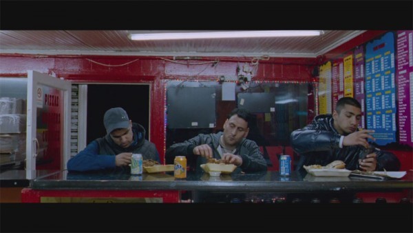 three men sitting at a table eating food