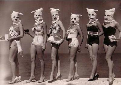 a group of women in bathing suits standing on a beach