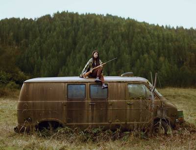 a woman sitting on top of an old van