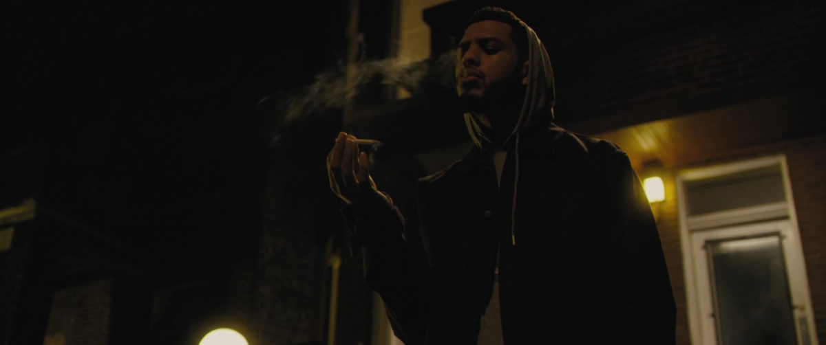 a man smoking a cigarette in the dark