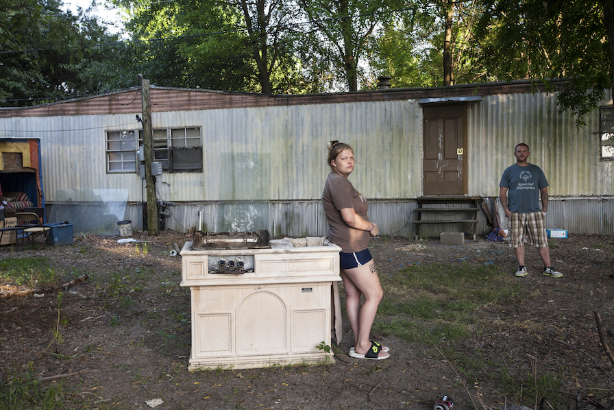 a woman standing next to a stove in a yard