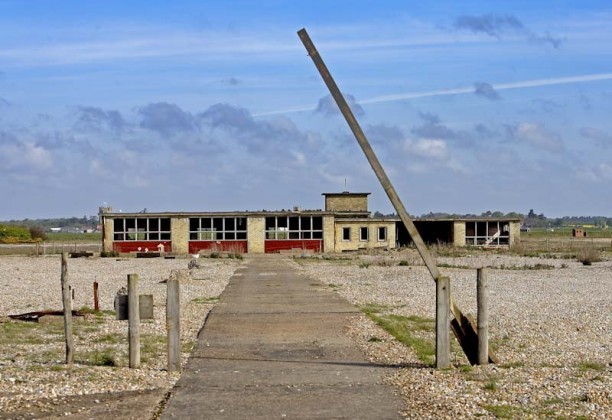 an abandoned building with a broken pole sticking out of the ground