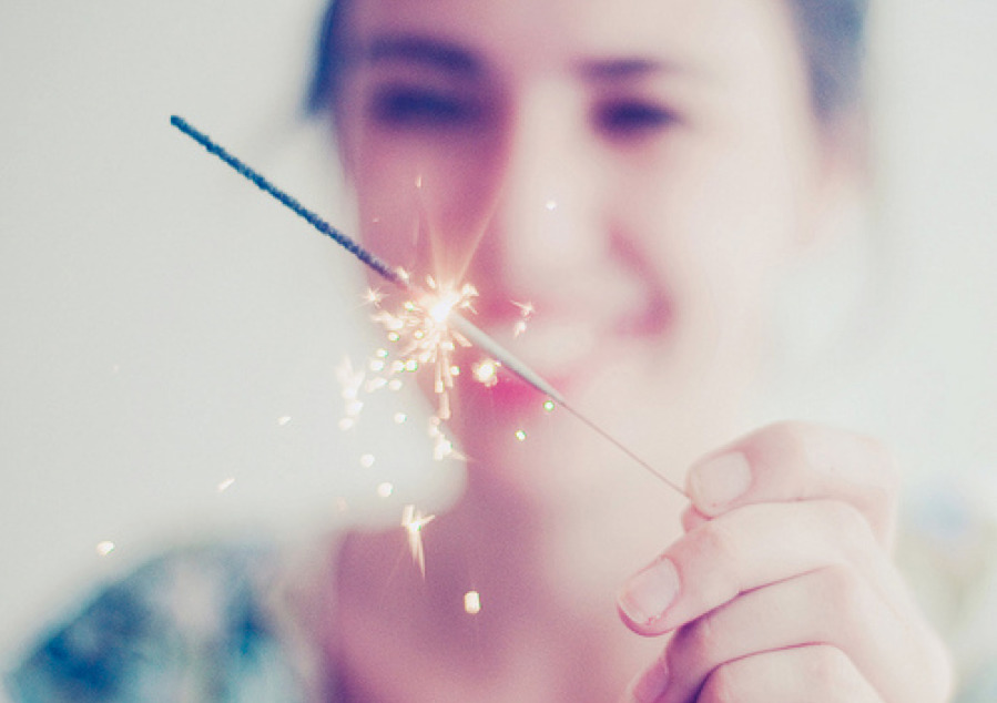 a woman holding a sparkler in her hand