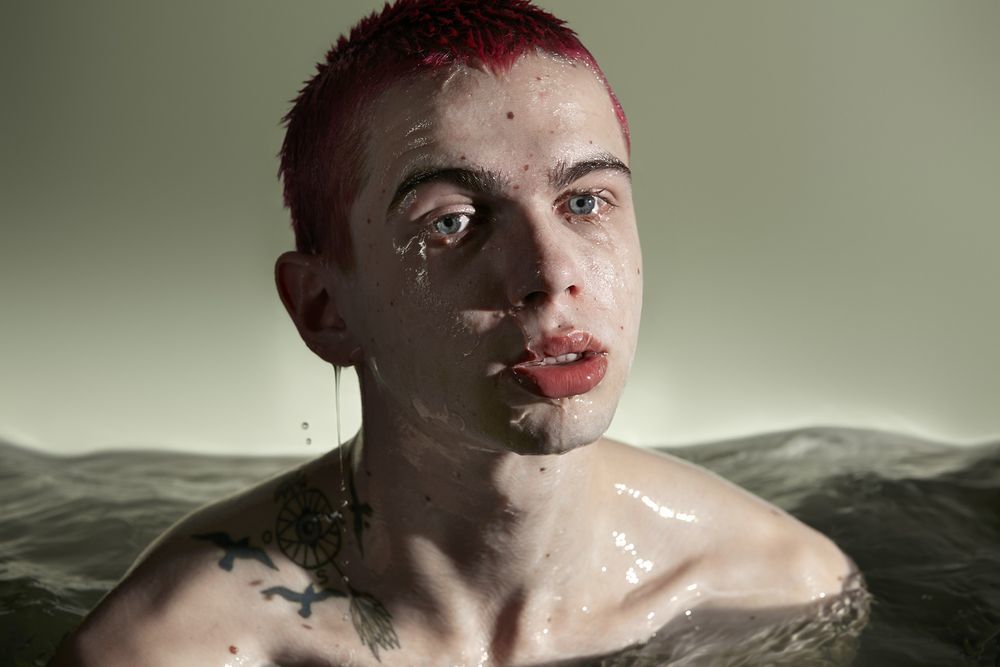 a man with red hair and piercings in the water