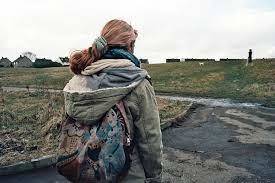 a woman with a backpack walking down a road