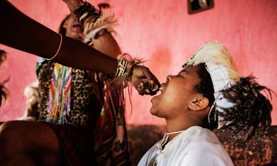 a young girl getting her hair combed by a woman