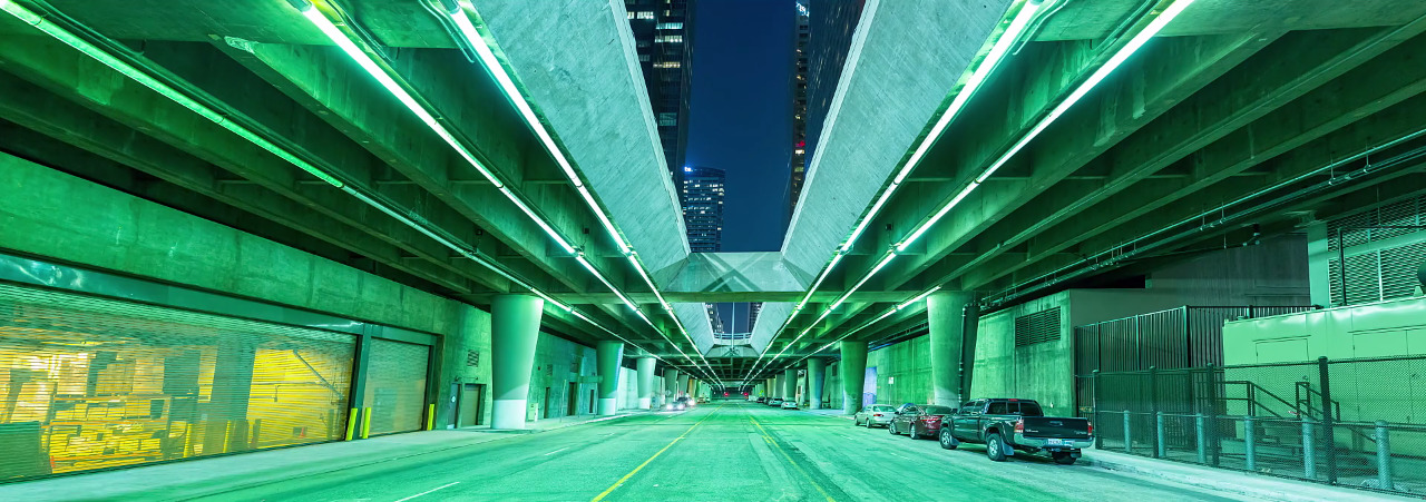 a city street at night with cars parked on the side of the road