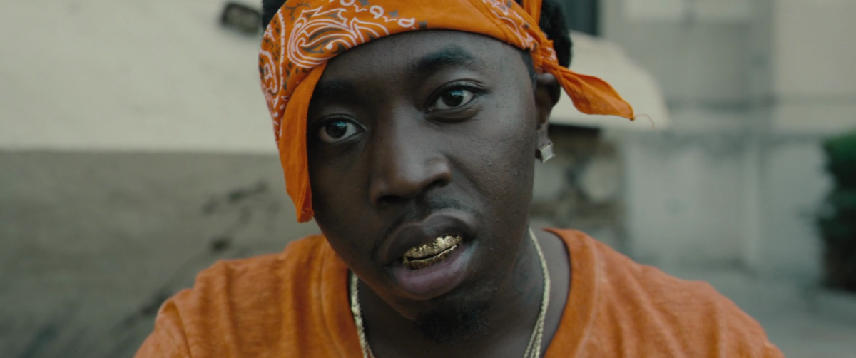 a man wearing an orange turban and gold necklace