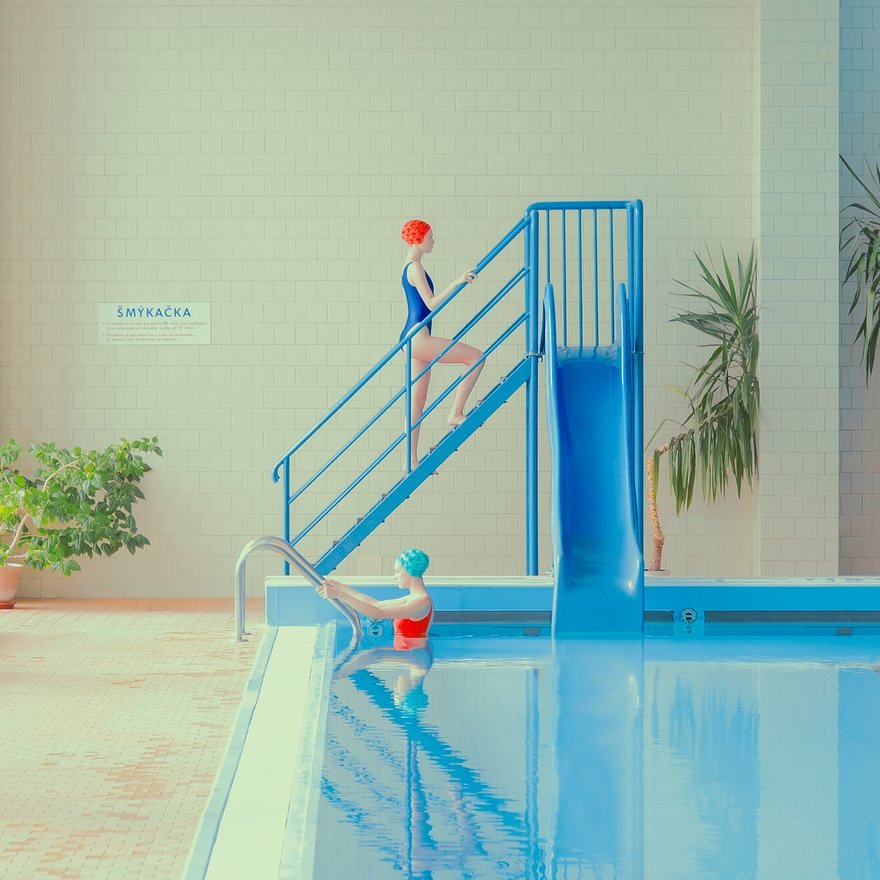 a woman in a bathing suit is standing on a stair case next to a pool