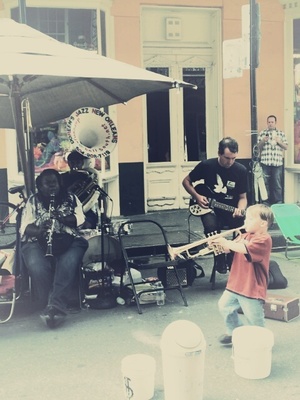 a young boy playing a trumpet in front of a band