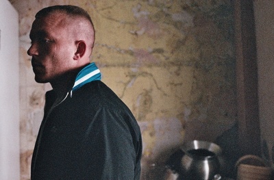 a man standing in a kitchen next to a wall