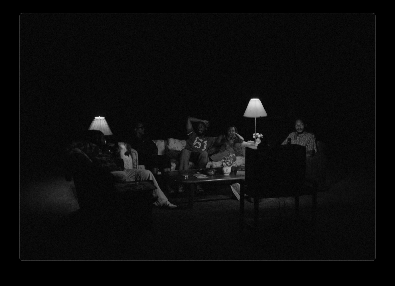 a group of people sitting around a table in the dark