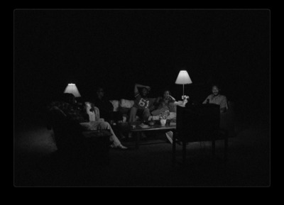 a group of people sitting around a table in the dark