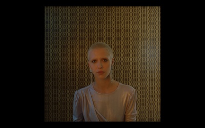 a woman standing in front of a wall with circles on it