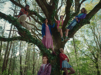 a group of children sitting in the branches of a tree