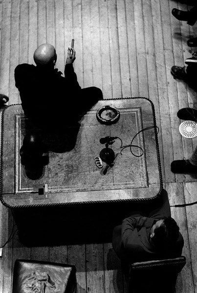 a black and white photo of a person sitting at a table