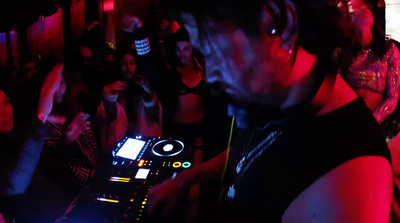 a dj mixing in front of a crowd of people