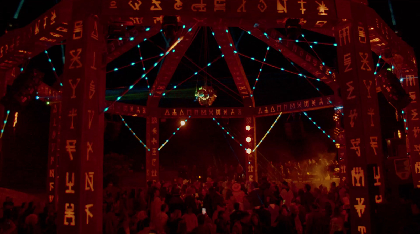 a group of people standing under a lit up structure