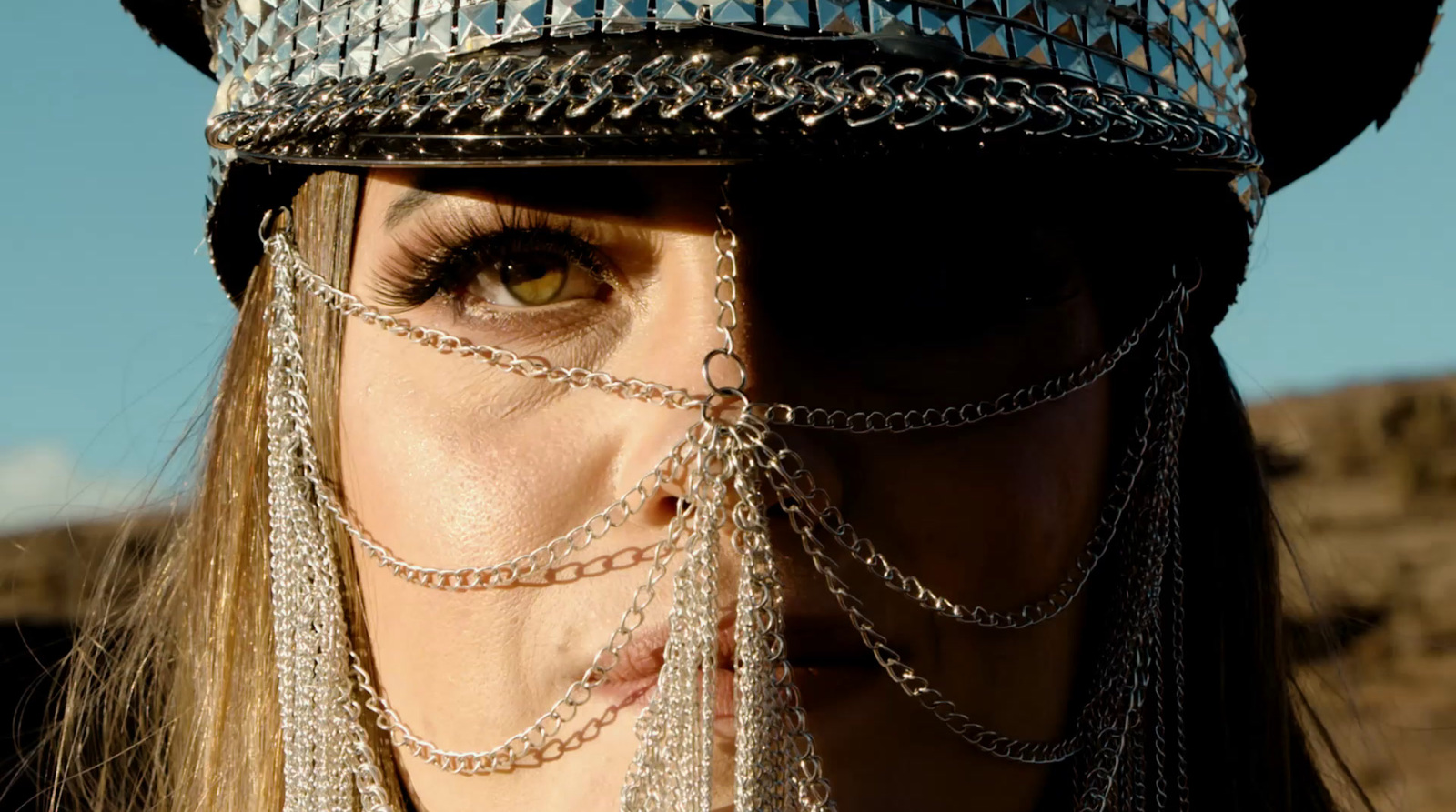 a close up of a person wearing a hat with chains on it