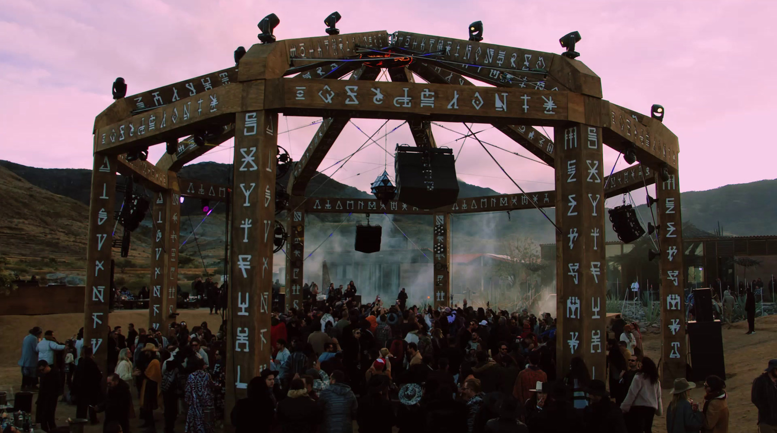 a crowd of people standing around a wooden structure