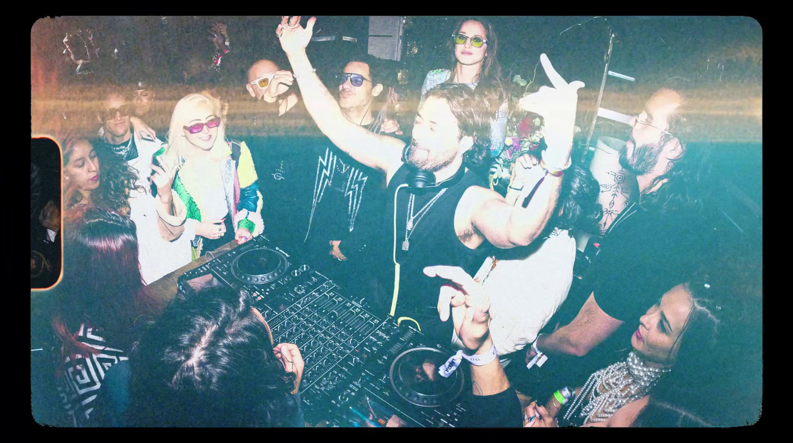 a group of people standing around a dj booth