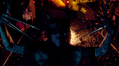 a man dressed as a catwoman holding two swords