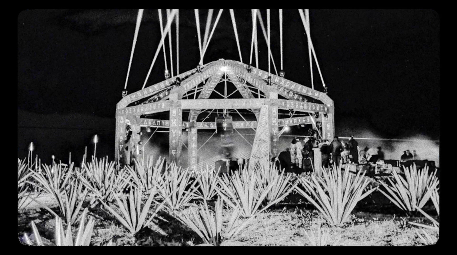 a black and white photo of a building surrounded by cacti