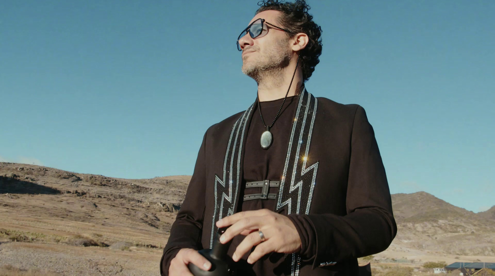 a man in a brown shirt and some mountains