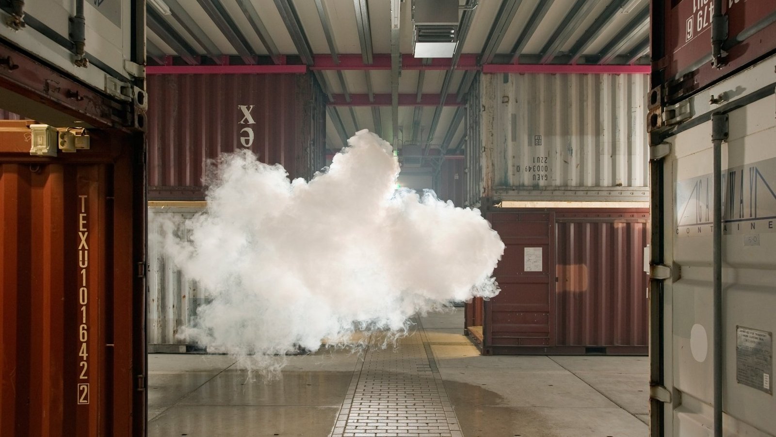 a large cloud of white smoke is coming out of a shipping container