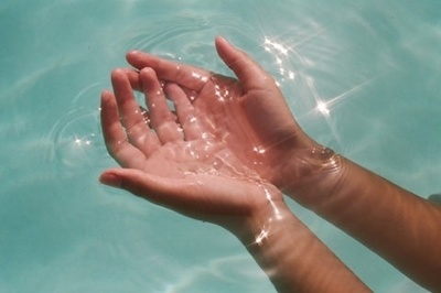 a person holding their hands in the water