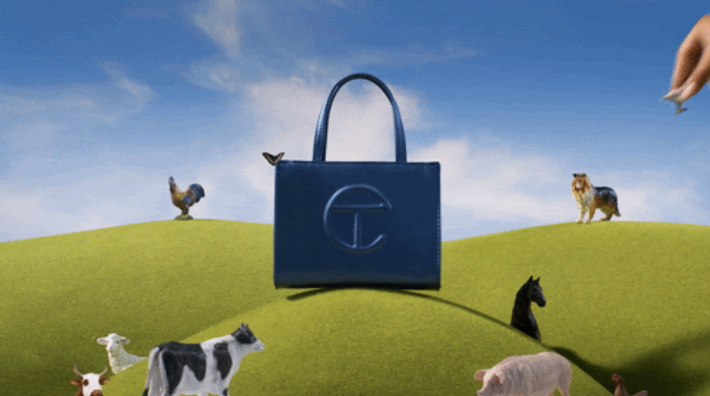 a painting of a hand holding a blue bag over a group of farm animals