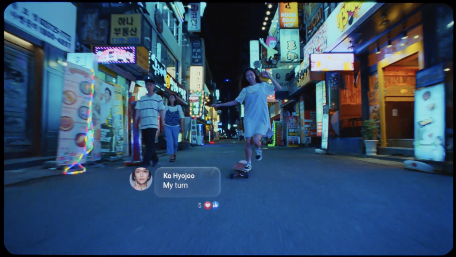 a man riding a skateboard down a street next to tall buildings