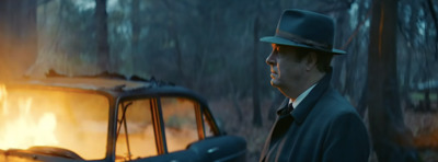 a man in a top hat standing next to a car