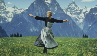 a woman in a field with mountains in the background