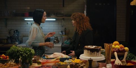 two women standing in a kitchen talking to each other