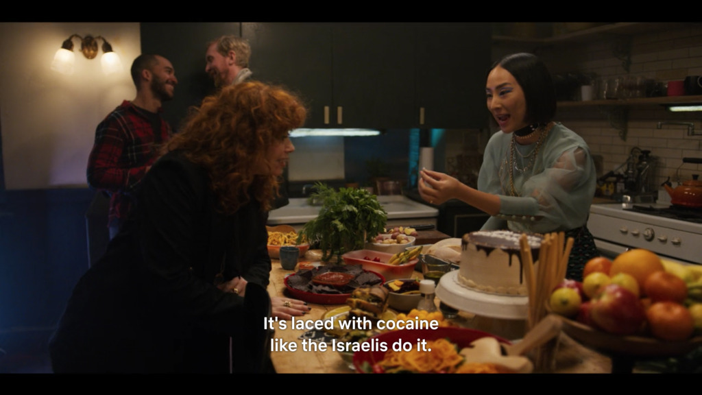 a group of people standing around a table with a cake