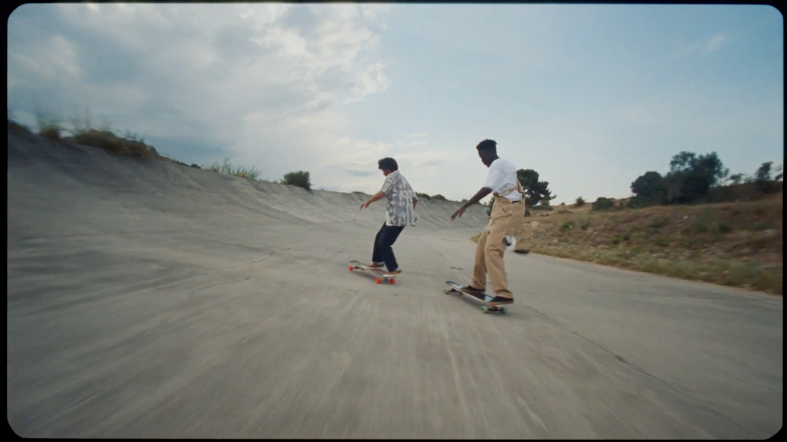 a couple of men riding skateboards down a street