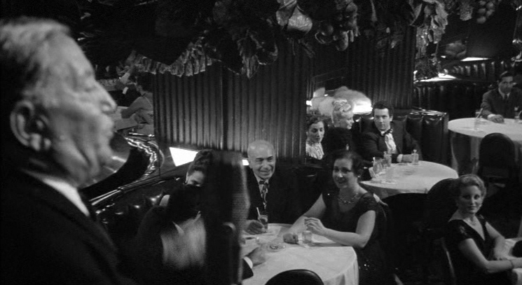 a group of people sitting around a table in a restaurant