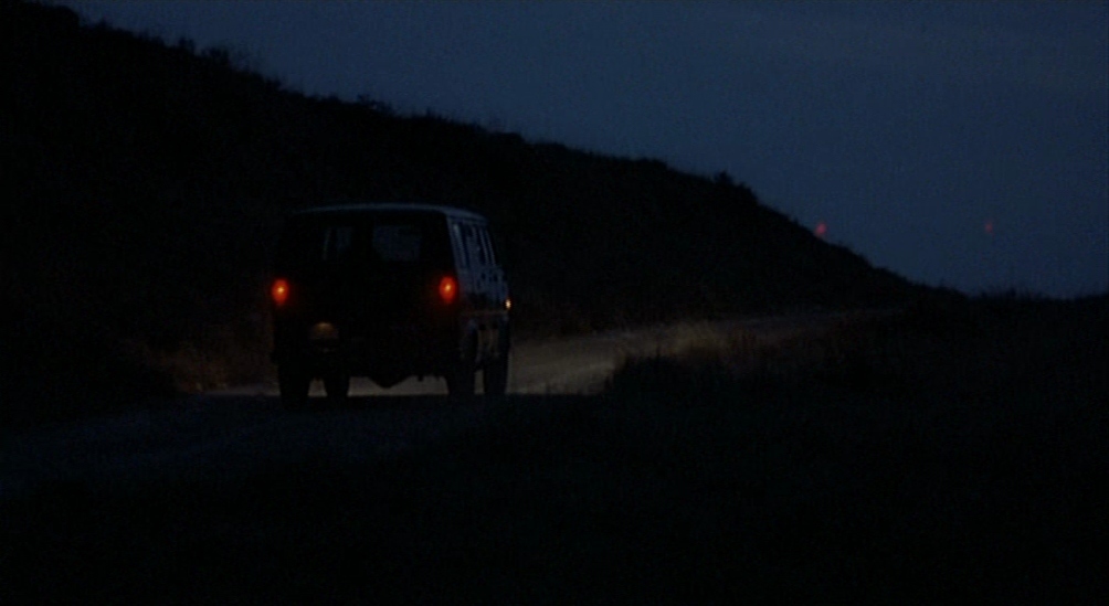 a car driving down a dark road at night