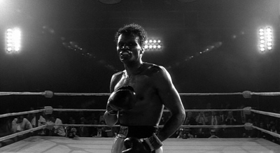 a black and white photo of a man in a boxing ring