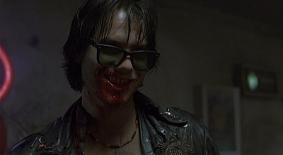 a man in a leather jacket and sunglasses with blood on his face