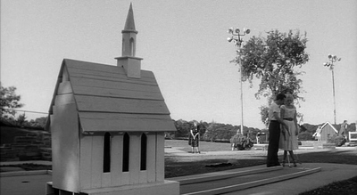 a woman standing in front of a small church