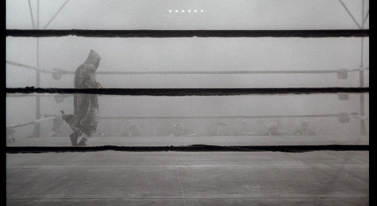 a black and white photo of a person in a boxing ring