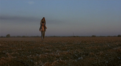 a person standing in a field with a sky background