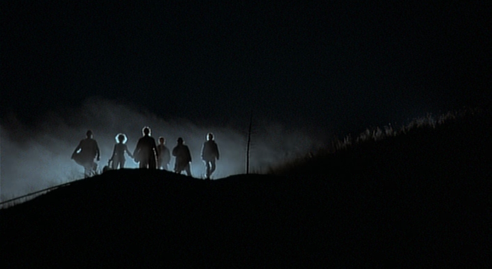 a group of people standing on top of a hill