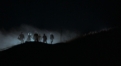 a group of people standing on top of a hill