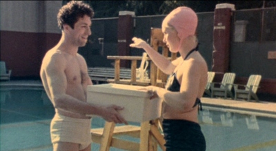 a man standing next to a woman holding a cooler