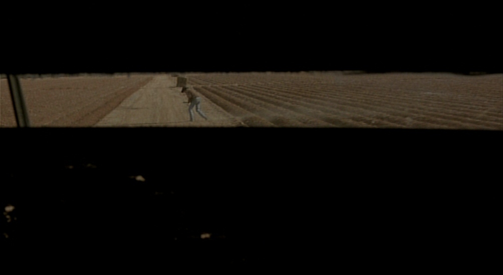 a person walking down a dirt road at night