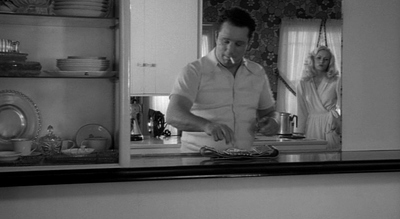 a man standing in front of a mirror in a kitchen