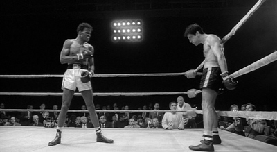 a couple of men standing on top of a boxing ring